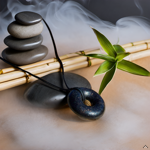 Black Sun Orgonite Pendant necklace featured with stones and green plant in a serene setting.